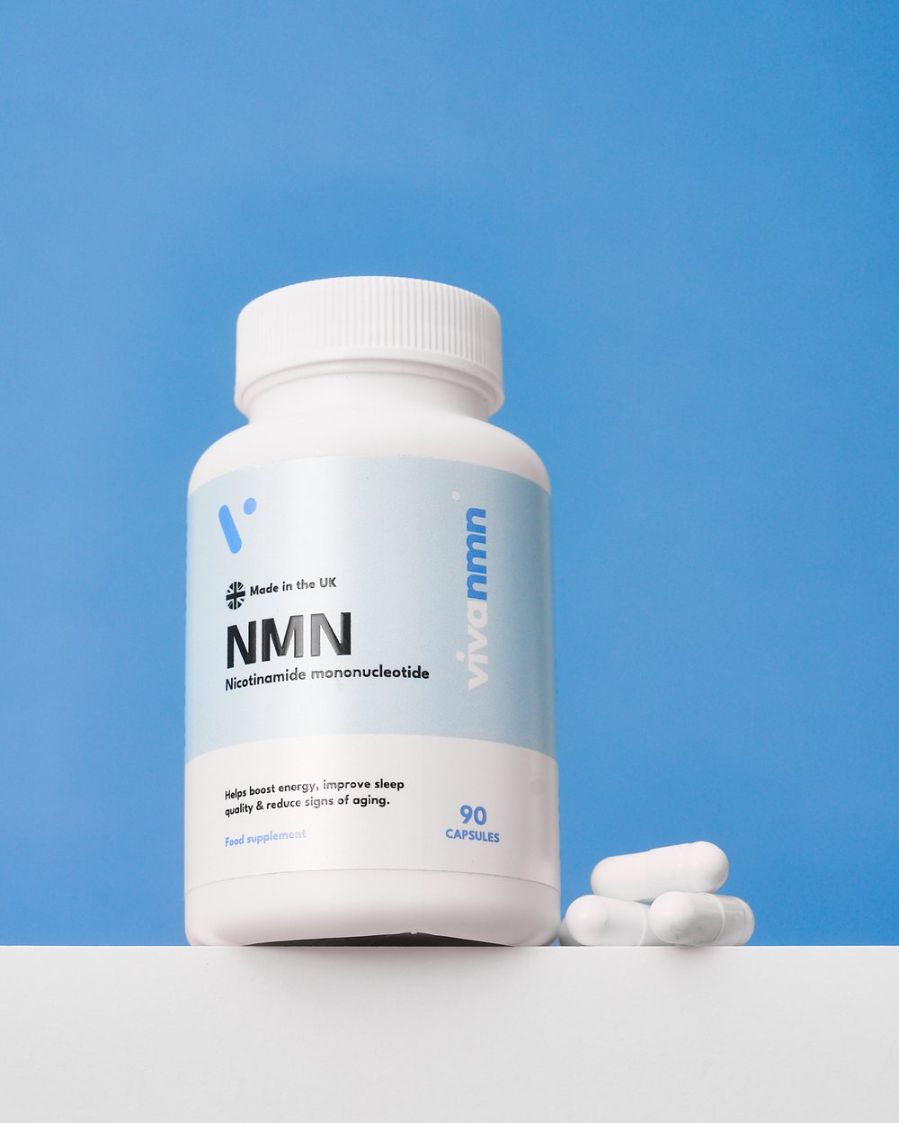 A bottle of vivanmn NMN with loose capsules on a blue background