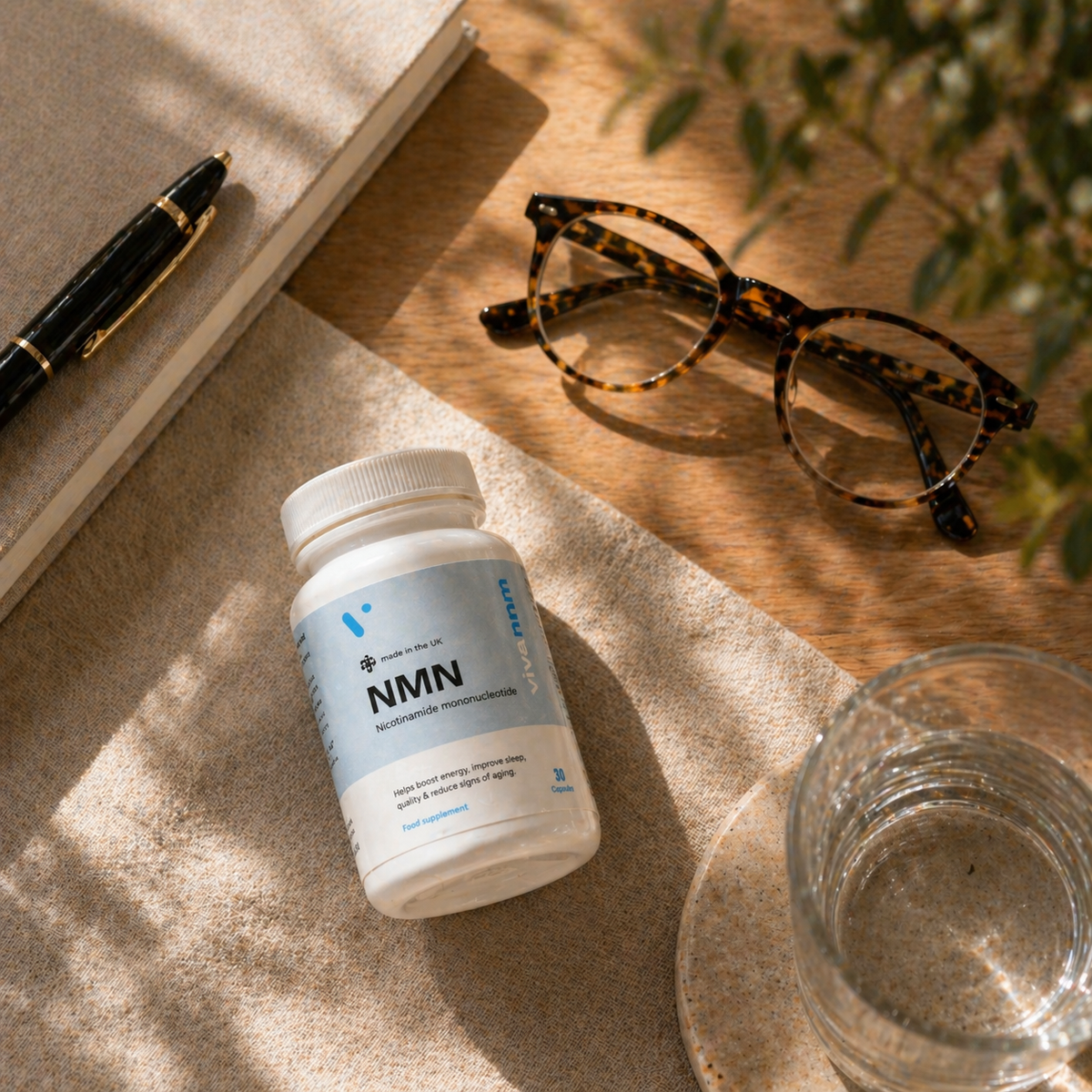 Vivanmn Pure NMN bottle beside reading glasses and a notebook