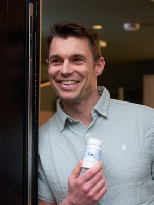 A man in a linen shirt holding vivanmn NMN